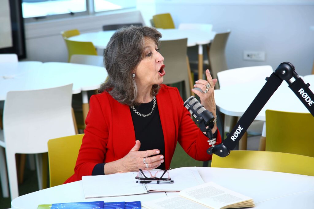 Professional receiving dynamic voice coaching while speaking into a microphone during training session.